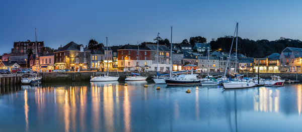 A Padstow Harbour scene with boats and buildings at dusk